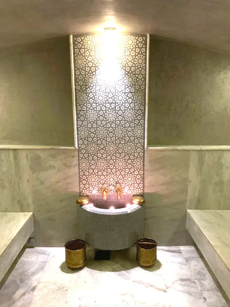Fontaine en zellige et seaux en laiton dans le hammam de So Spa